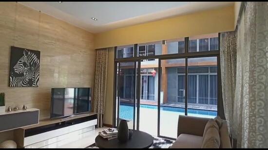 Spacious living area with high ceiling next to the pool.